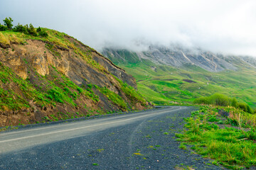 A mountain road high in the mountains among low clouds. The North Caucasus. Russia