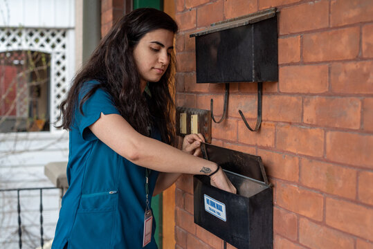 LGBTQ+ nurse checking the mailbox of her home