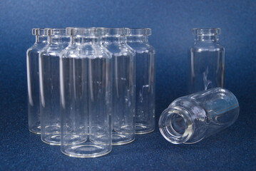 glass medical bottles for drugs or vaccines on a blue background