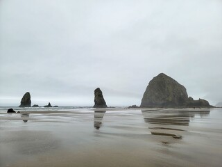 Serene view of Haystack Rock and the Needles at Cannon Beach, Oregon on a cloudy day