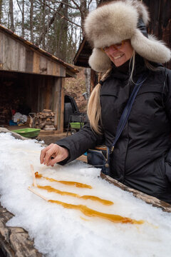 Happy woman winter portrait with maple taffy