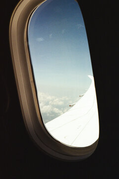 A plane window with a sky and sea view