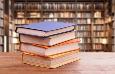 stack of reading books on desk in library