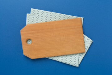 Cutting board with napkin on color background, top view