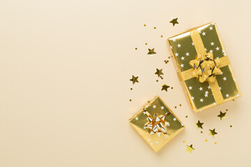 Golden gift boxes and confetti on color background, top view