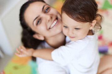 happy mother with cute baby girl in white t-shirt having fun together