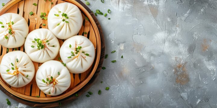 Top view steaming bao buns with chopped scallions in bamboo steamer on gray surface. Banner with copy space