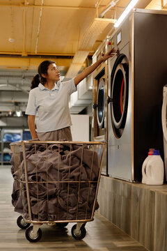 Woman Choosing Program On Washing Machine