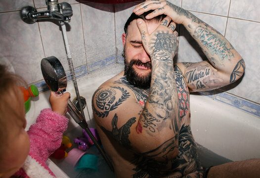 A man gets doused with a showerhead. 