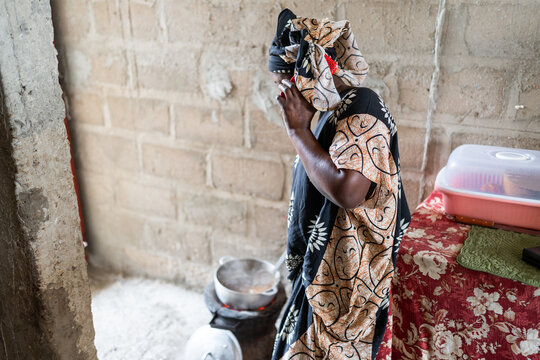 Senegalese woman cooking traditional food in humble kitchen