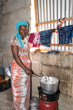 Senegalese woman cooking traditional food on a gas stove