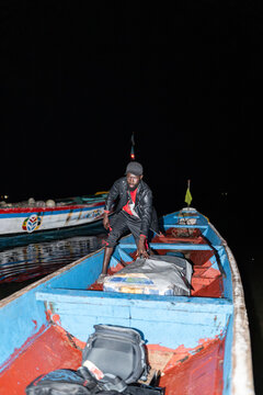 Senegalese fisherman preparing his wooden pirogue at night