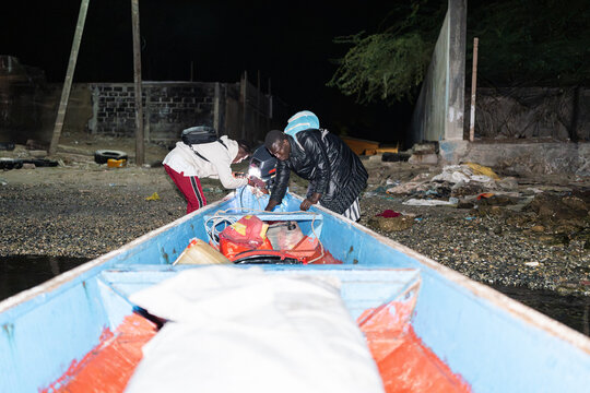 Senegalese fishermen preparing their boat at night in mbour, senegal