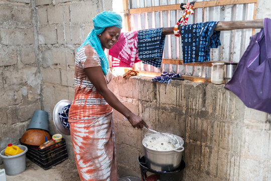 Senegalese woman cooking traditional food in her kitchen