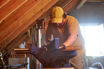 man sawing wood on a jointer in a home workshop