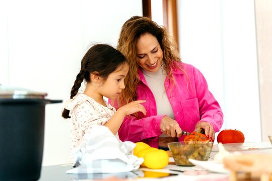 Mother and Daughter Cooking in Kitchen
