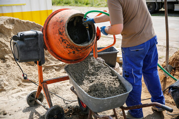 Constriction worker making concrete in an orange mixer