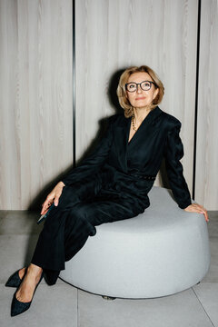 Elegant businesswoman sitting on stool