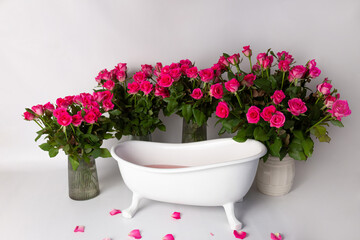 white bathtub with pink flowers. big bouquets pink roses
