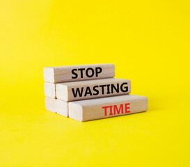 Stop Wasting Time symbol. Wooden blocks with words Stop Wasting Time. Beautiful yellow background....
