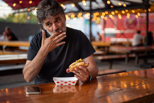 Man licking finger while eating