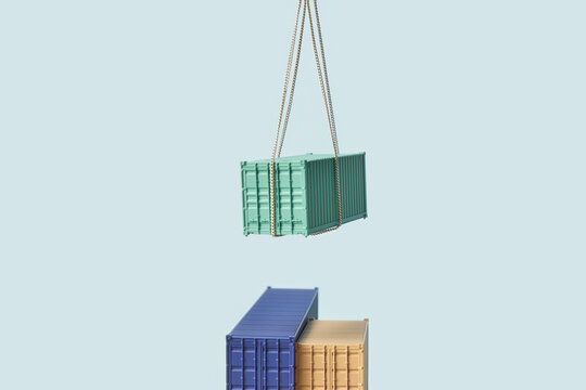 Iron box fixed by rope rising above blue and yellow containers