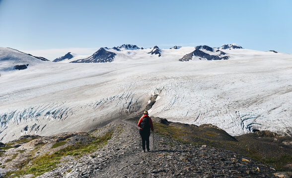 Hiker on mountain ridge with glacier in the background 