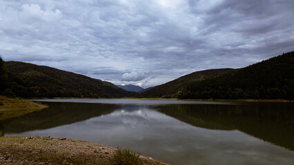 Colorful landscape with forest, lake, reflection in water