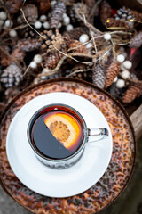 Red mulled wine drink with a slice of orange in a glass cup, top view.