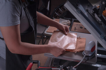 Working woman in her workshop doing the sublimation process with a heat press.