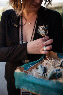 woman puts a flower in her lapel