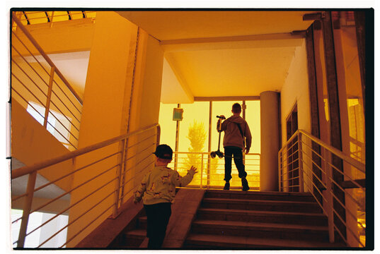 Two brothers walk along a ground-level pedestrian.