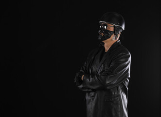 Portrait of a biker in a black helmet on a black background