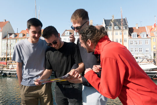 friends visiting copenhagen and looking at a map very happy 