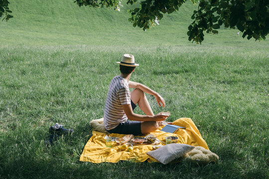 A man with the hat on a picnic blanket