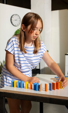 Young Girl Experimenting With Dominos