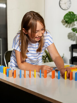 Young Girl Experimenting With Dominos