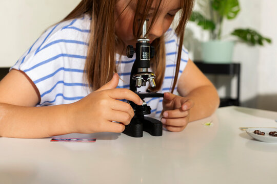 pre-teen girl using microscope