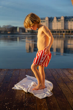 A boy warms his feet on a towel at the sauna in December in Oslo