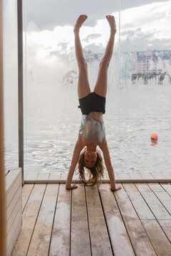 Girl doing a headstand in a sauna