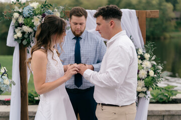 bride and groom exchanging rings during wedding ceremony