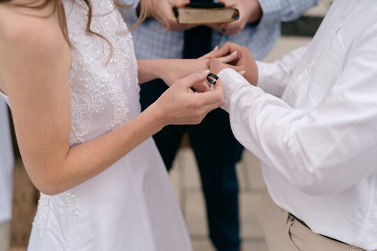 bride and groom exchanging rings during wedding ceremony