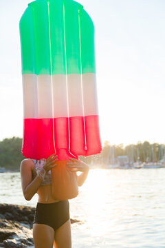 A girl carries an inflatable popsicle raft