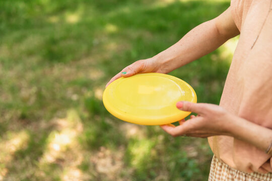 Unrecognizable Person Playing Frisbee in Park