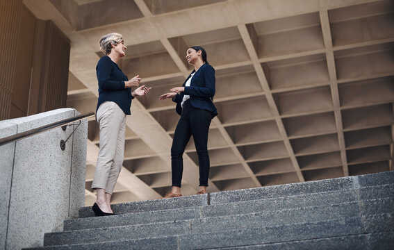 Stairs, discussion and business women in city for collaboration, partnership or project feedback. Low angle, meeting and financial broker with client for consulting, advice or conversation on steps