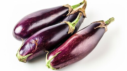   A trio of eggplants rest atop a white countertop