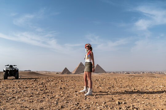 Woman adventurer on tourism quad bike ride near pyramids