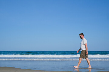barefoot man walking along the shore, office scape and recreation