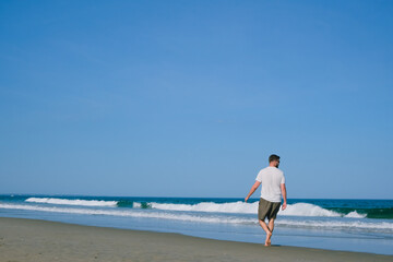 barefoot adult man walking on the beach, office scape and happy life