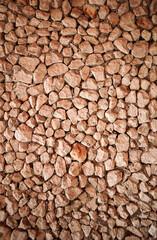 Brown stone on the wall. Stone designs with pebbles at wall.Vertical.